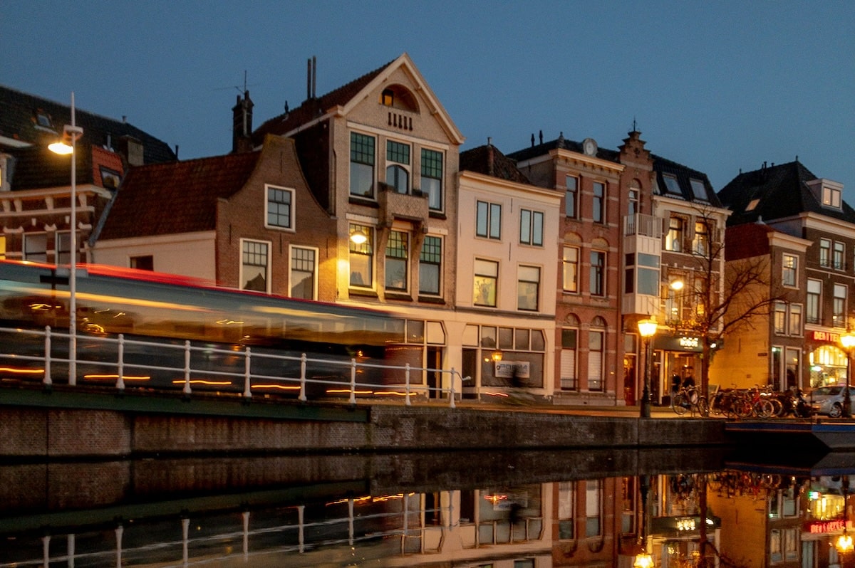 Car passing houses at night